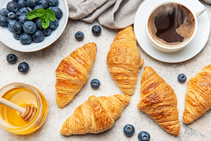 Delicious continental breakfast with croissants, coffee, honey a, a Food & Drink Photo by Olena Rudo