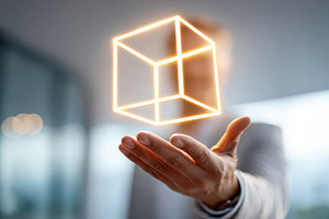 Person holding a glowing 3D cube in hand, a Business Photo by AlyaAnd