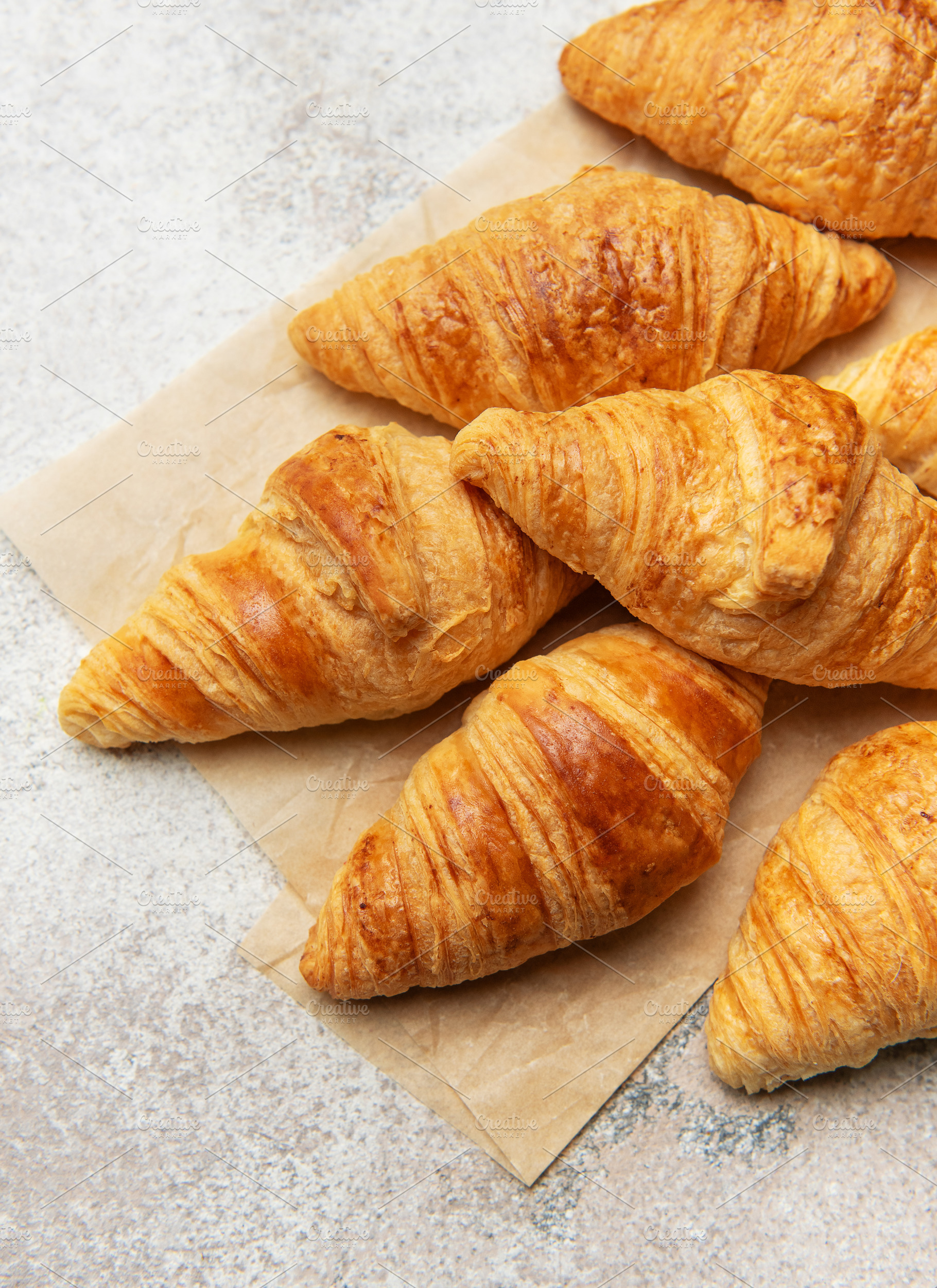Freshly baked croissants with wheat on baking paper, a Food & Drink Photo by Olena Rudo