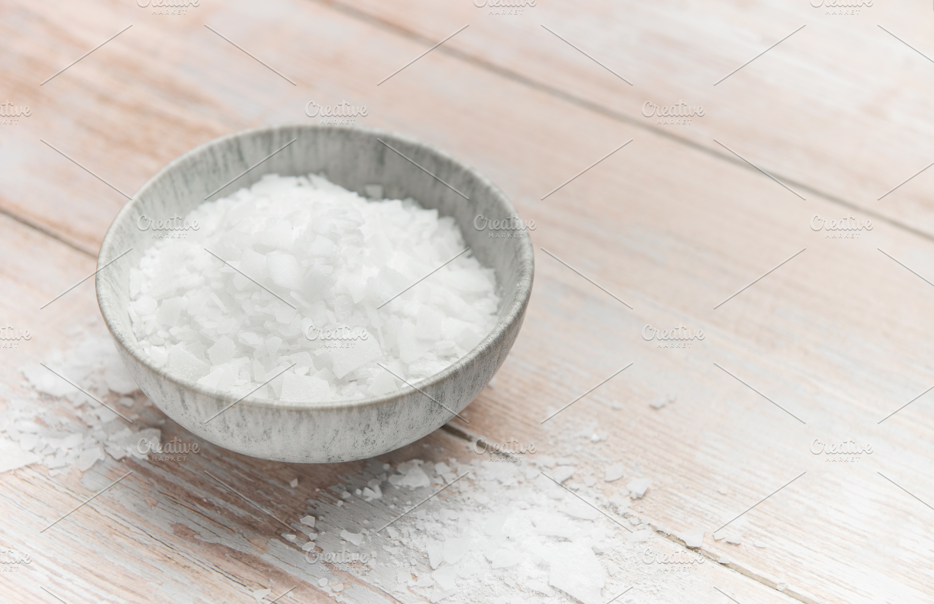 Magnesium chloride flakes in a bowl on rustic wooden table, a Health & Medical Photo by Olena Rudo