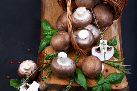 Fresh champignon mushrooms on dark wooden table