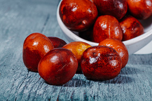 jujube fruits on a gray wooden table, a Photo by Nito