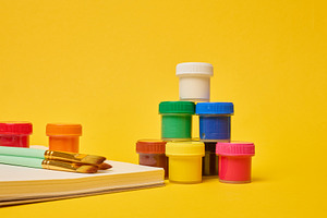 White spiral notebook, brushes and colorful paint cans symbolizi, a School & Education Photo by ndanko