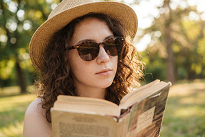 Young Woman Reading Book in a Park, a Person Photo by Virgo Studio
