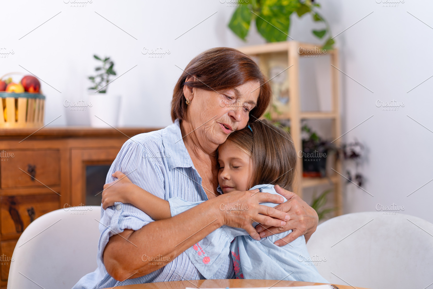 Cute loving girl embracing grandmother while spending quality moment, a Photo by andreonegin market