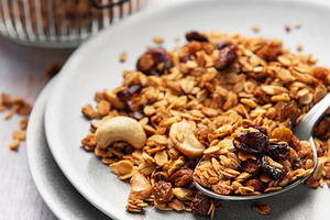 Healthy homemade granola mix on plate with spoon, a Food & Drink Photo by Olena Rudo