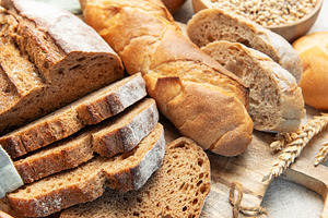 Assorted fresh bread, baguette, and croissants on cutting board, a Food & Drink Photo by Olena Rudo