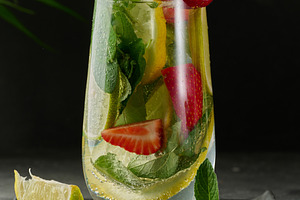 A refreshing drink in a glass with lemon slices, strawberries, f, a Food & Drink Photo by ndanko