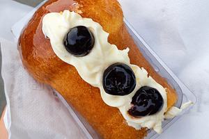 Rum baba with whipped cream and cherries resting on white napkin, a Food & Drink Photo by Antonio Gravante Market