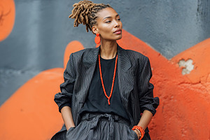 Influencer woman poses stylishly against vibrant mural in urban setting, a Person Photo by OSORIOartist
