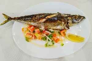 Grilled mackerel fish on white plate with salad, a Food & Drink Photo by DanFLCreativo