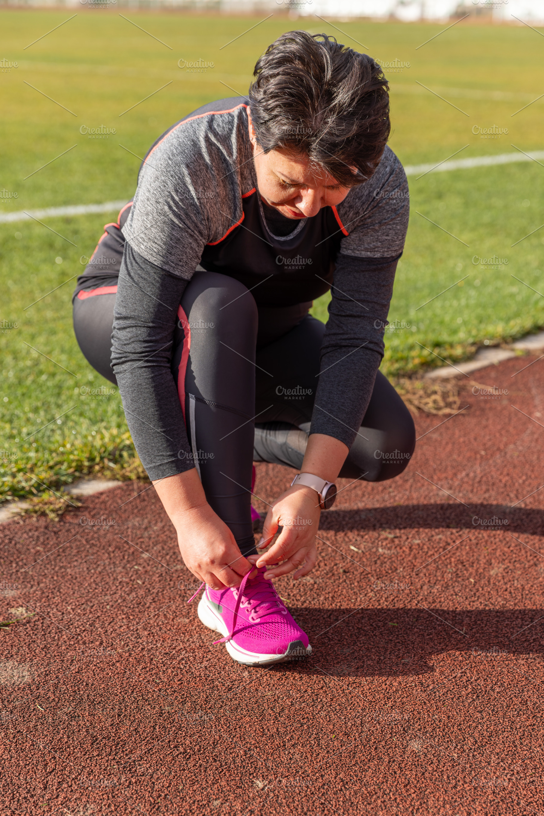Woman tying shoelaces, a Photo by Grafvision photography