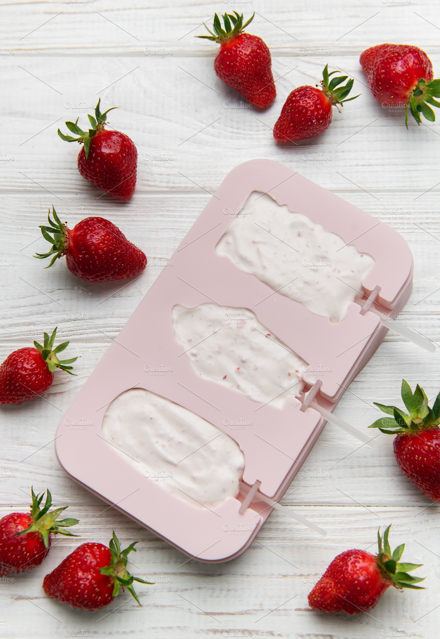 Homemade strawberry ice cream pops preparation on wooden backgro, a Food & Drink Photo by Olena Rudo