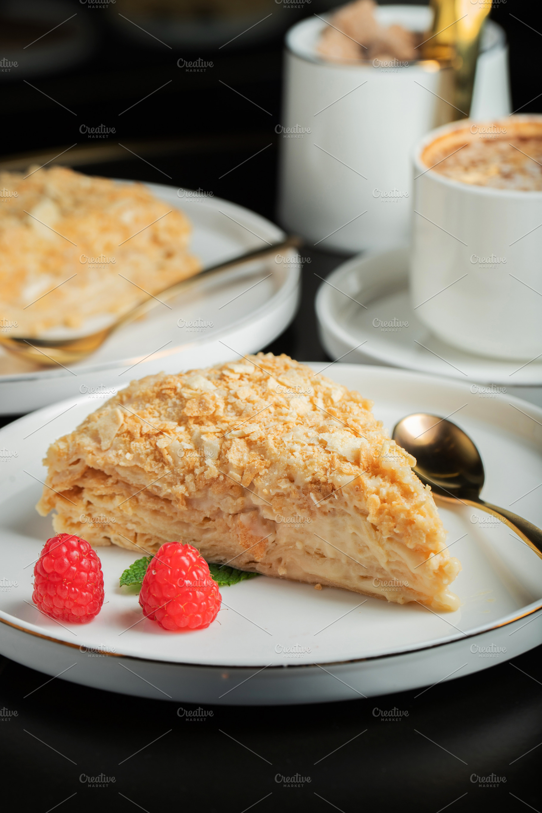 Sliced Napoleon cake on a white wooden table. Classic dessert, a Food & Drink Photo by Budarinphoto
