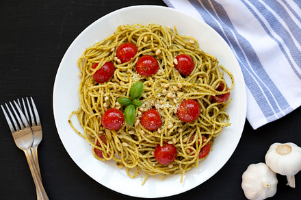 Homemade Pesto Pasta with Tomatoes and Pine Nuts on a black surf, a Food & Drink Photo by LiudmylaChuhunova