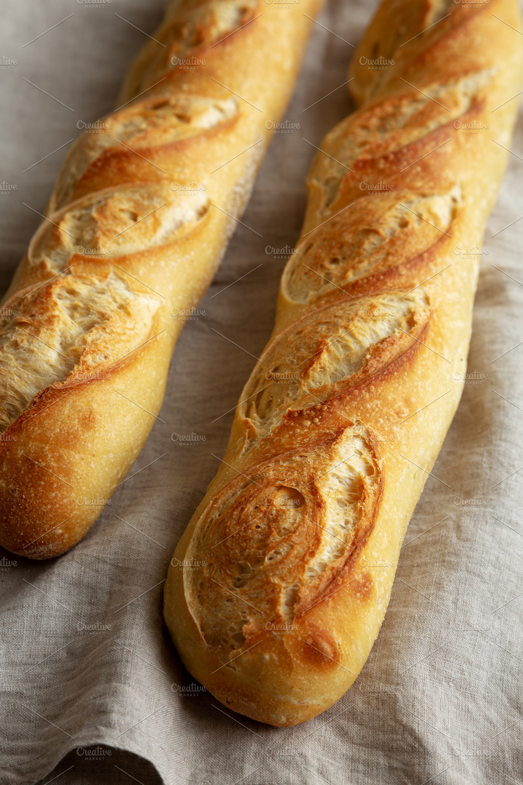 Homemade French Bread Baguette on a gray background, side view., a Food & Drink Photo by LiudmylaChuhunova