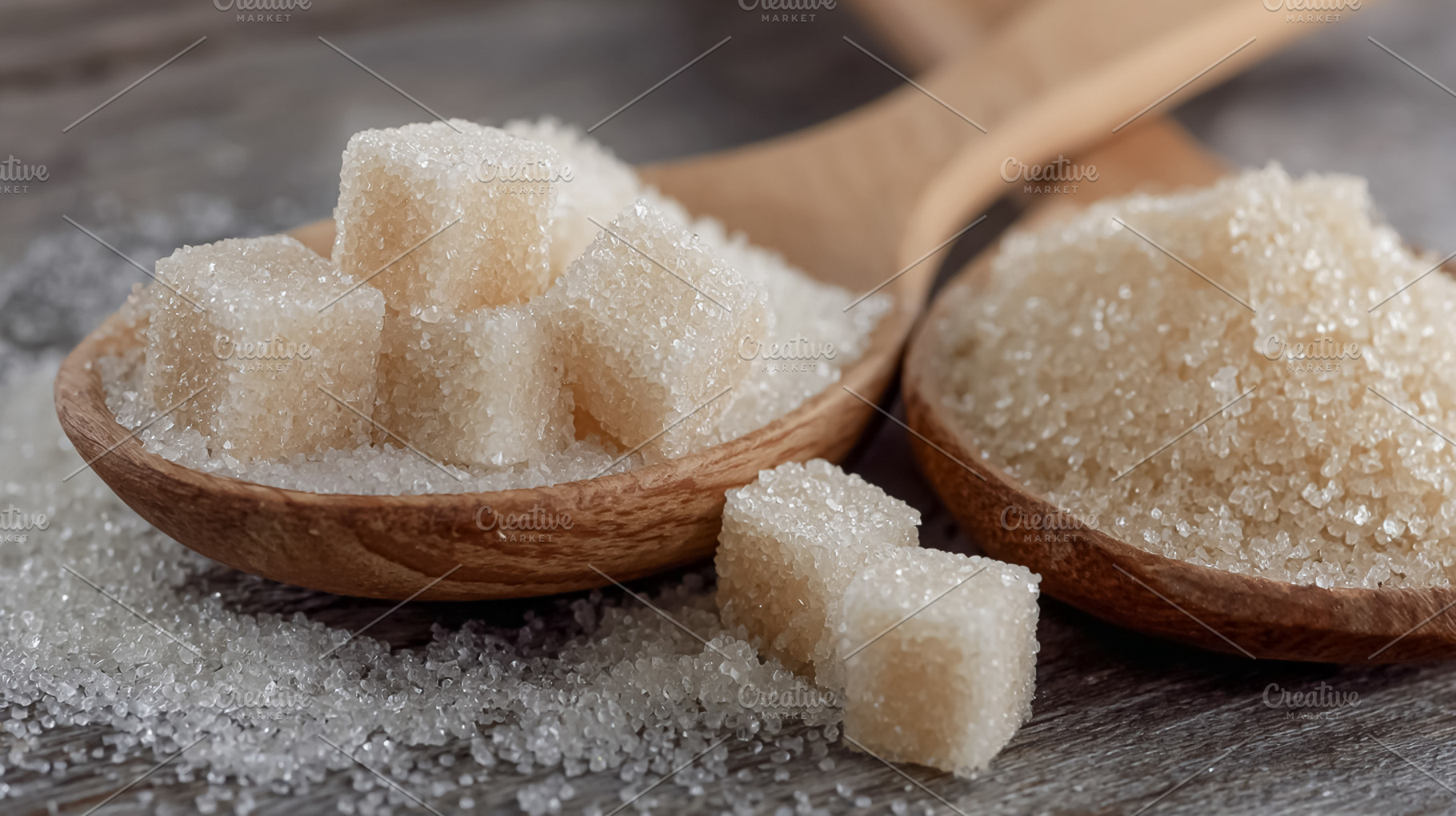 White sugar cubes and granulated sugar in wooden spoons, with br, a Photo by Studio ANNA