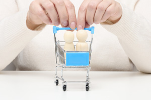 Woman's hands holding a miniature supermarket cart with wooden h, a Person Photo by ndanko