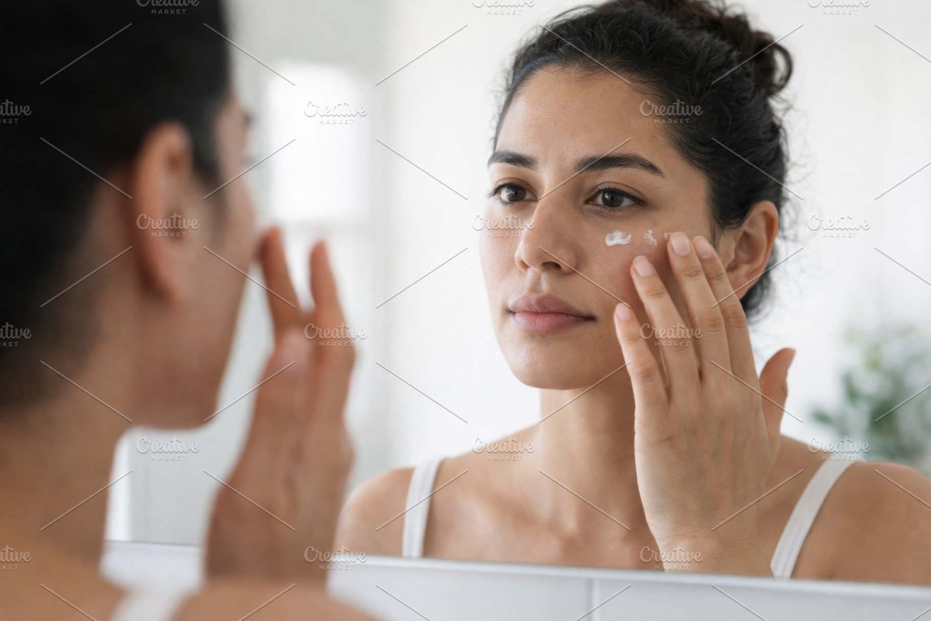 Woman applying cream to face for sum, a Photo by Dvoevnore photos