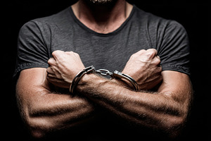 Man with crossed arms in handcuffs, a Person Photo by AlyaAnd