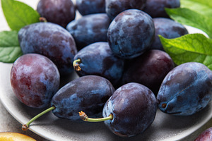 Fresh ripe plums, whole and halved on plate, a Food & Drink Photo by Olena Rudo