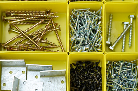 Various metal screws in separate yellow plastic containers., an Abstract Photo by ndanko