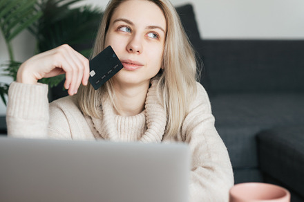 Young woman holding credit card and using laptop computer., a Business Photo by Olena Rudo