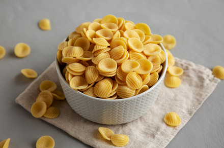 Dry, Uncooked Orecchiette Pasta in a Bowl, side view., a Food & Drink Photo by LiudmylaChuhunova