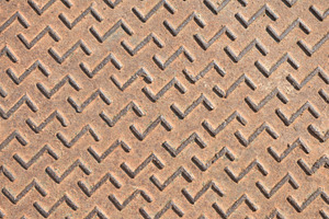 Detail of rusty metal manhole cover with engraved pattern, a Background Photo by Davizro's Market