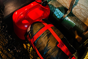 Compact travel cargo in a vehicle trunk with red gas can and strapped gear, a Photo by AS photostudio