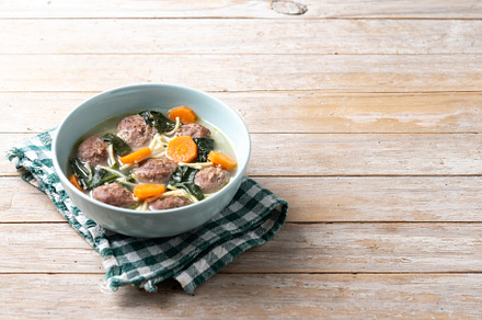 Italian Wedding Soup with meatballs and spinach on wooden table, a Food & Drink Photo by etorres69