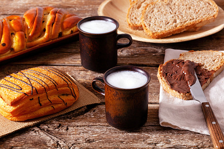 Delicious breakfast with whole wheat bread, chocolate cream, pastries and milk, a Food & Drink Photo by Antonio Gravante Market