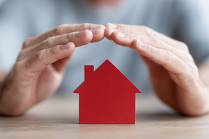 Hands protectively covering a house, a Business Photo by MistyDay
