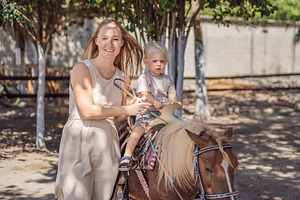Mother and toddler enjoy a pony, a Person Photo by Elizaveta Galitskaya