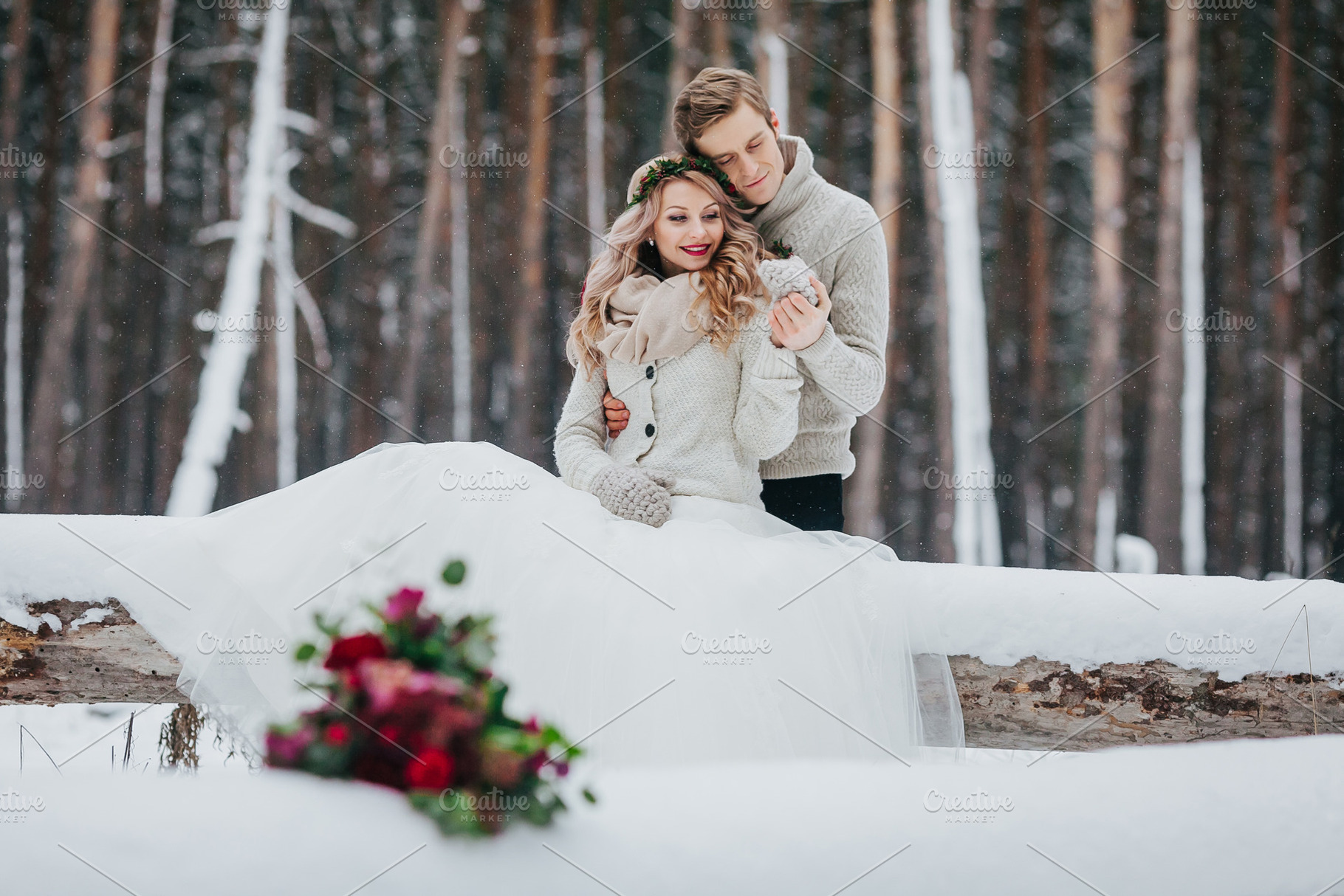 Bride and groom are sitting on the log in the winter forest. Close-up. Winter wedding. Soft focus on the couple, a Person Photo by Stahov