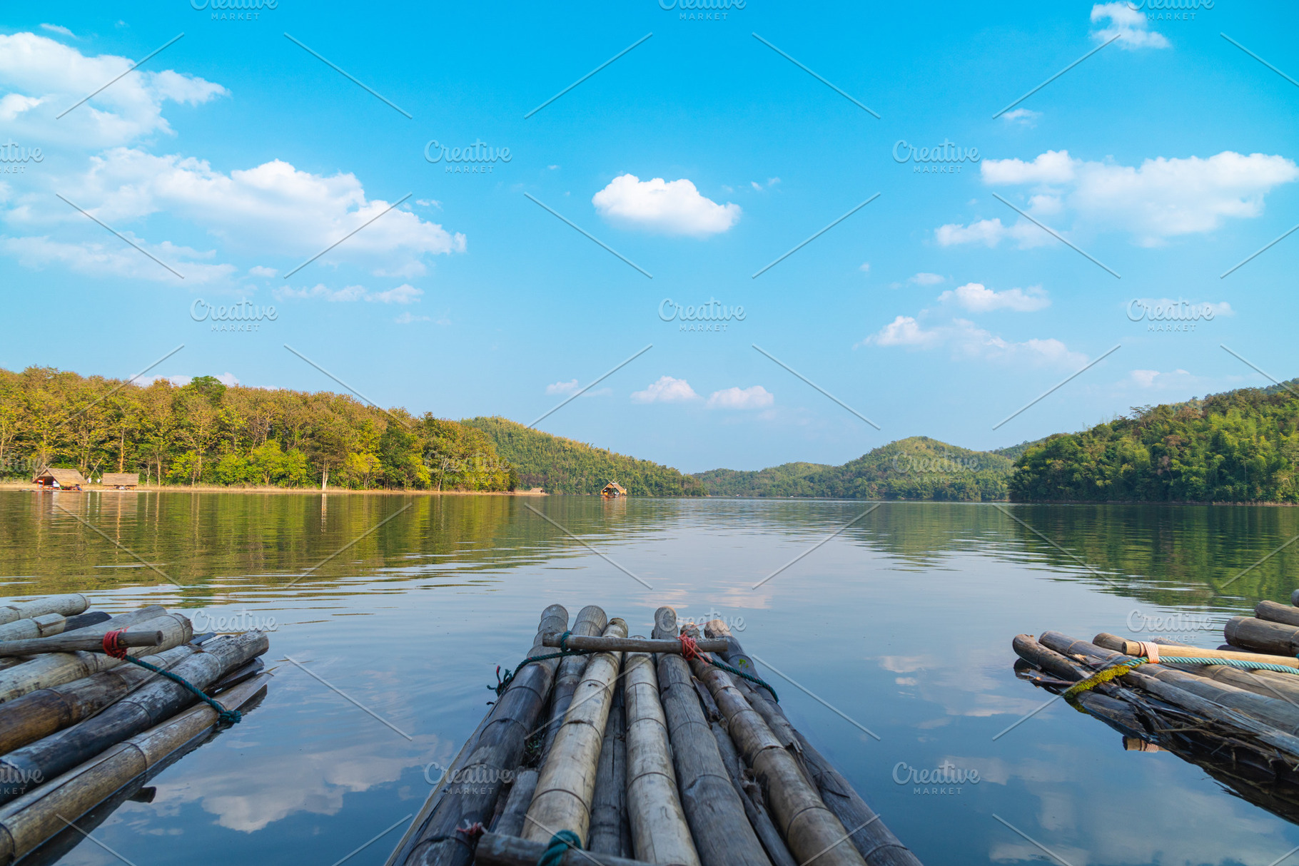 A serene view of bamboo rafts floating on calm lake, surrounded by lush green h, a Nature Photo by a454