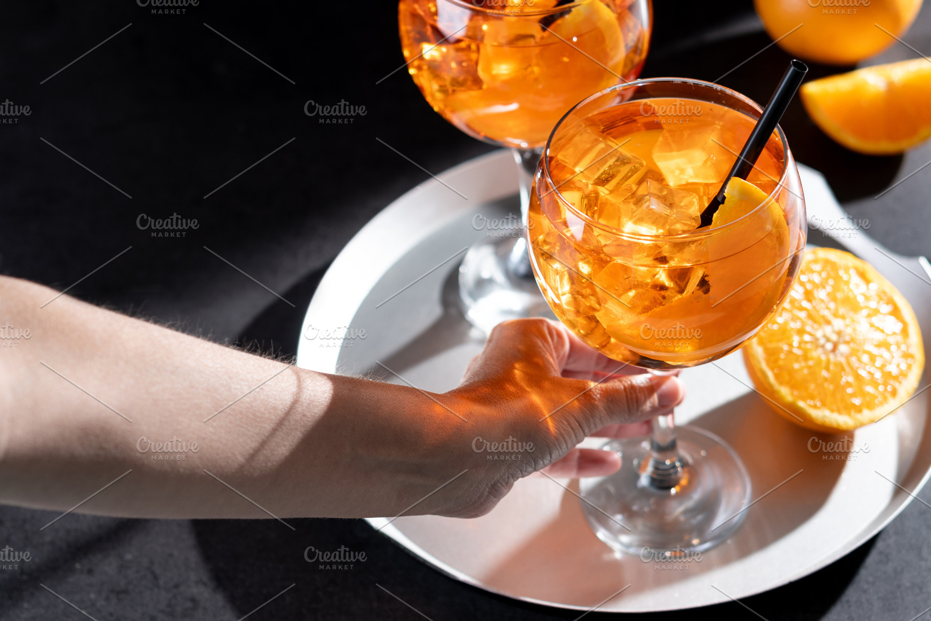 Woman holding refreshing Aperol Spritz cocktail with orange slices and ice, a Food & Drink Photo by etorres69