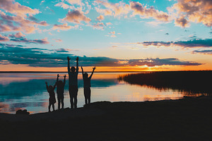 happy family at sunset lake