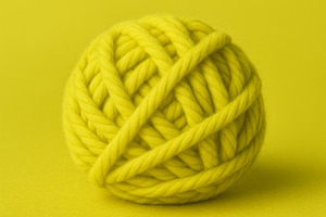 Ball of yellow yarn on matching char, a Photo by Dvoevnore photos