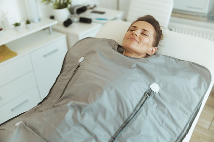 woman doing whiskey swaddling procedure in thermal blanket, a Health & Medical Photo by Alliance Images
