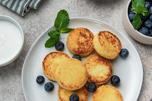 Syrniki cottage cheese pancakes with fresh blueberries and mint, a Food & Drink Photo by Olena Rudo