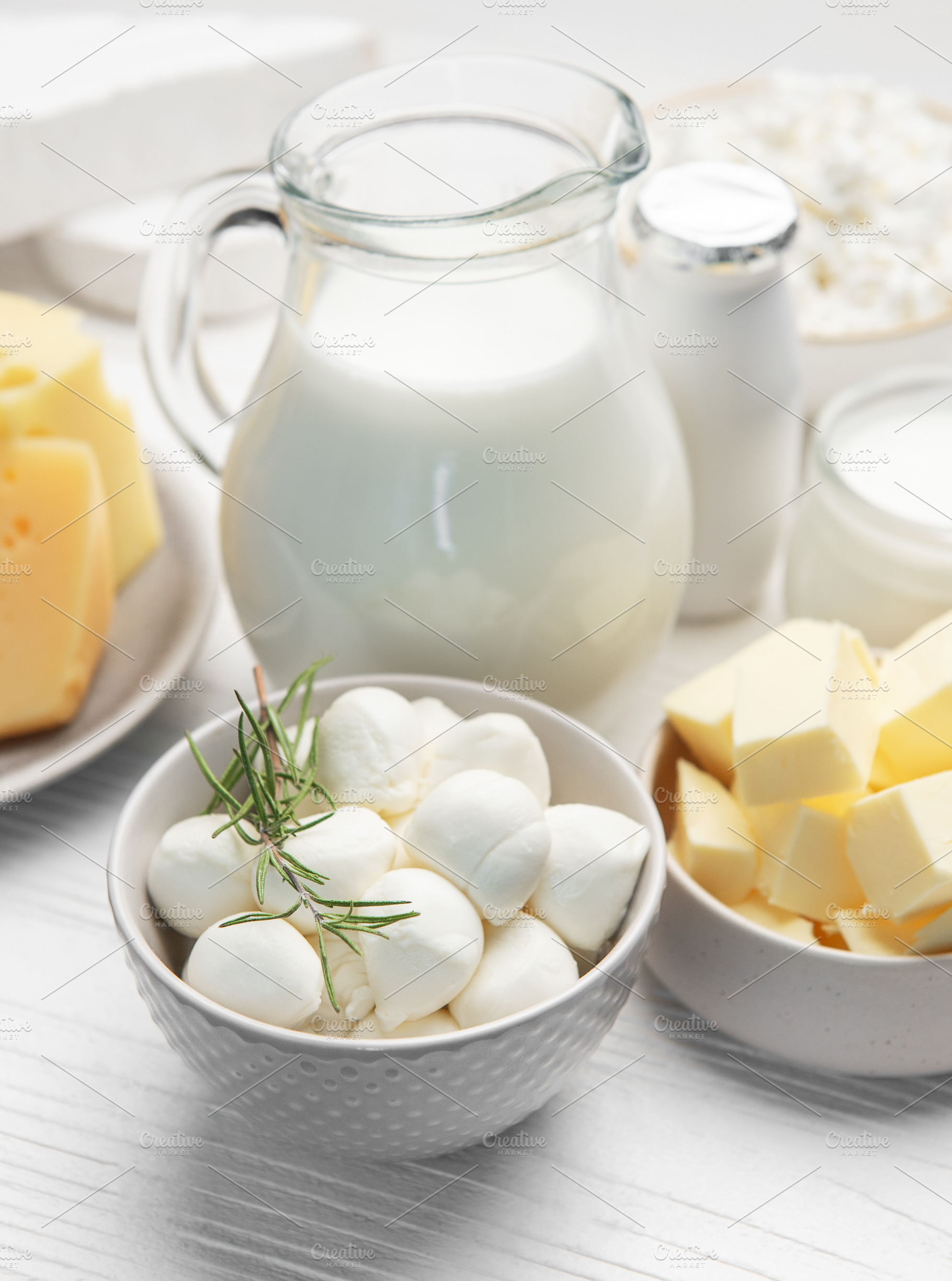 Assortment of fresh dairy products on white table, a Food & Drink Photo by Olena Rudo