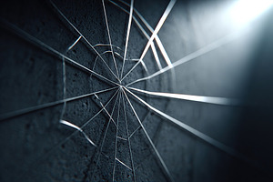 Delicate spider web glistening in soft light against a textured grey wall, a Photo by AlyaAnd
