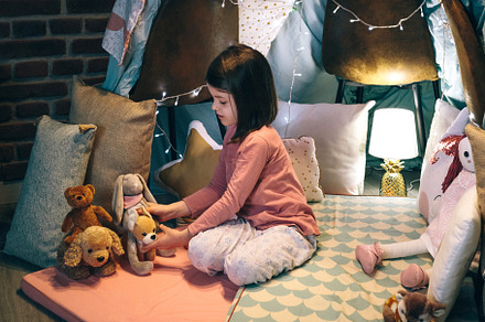 Girl playing with stuffed animals in a teepee, a Person Photo by davidpereiras