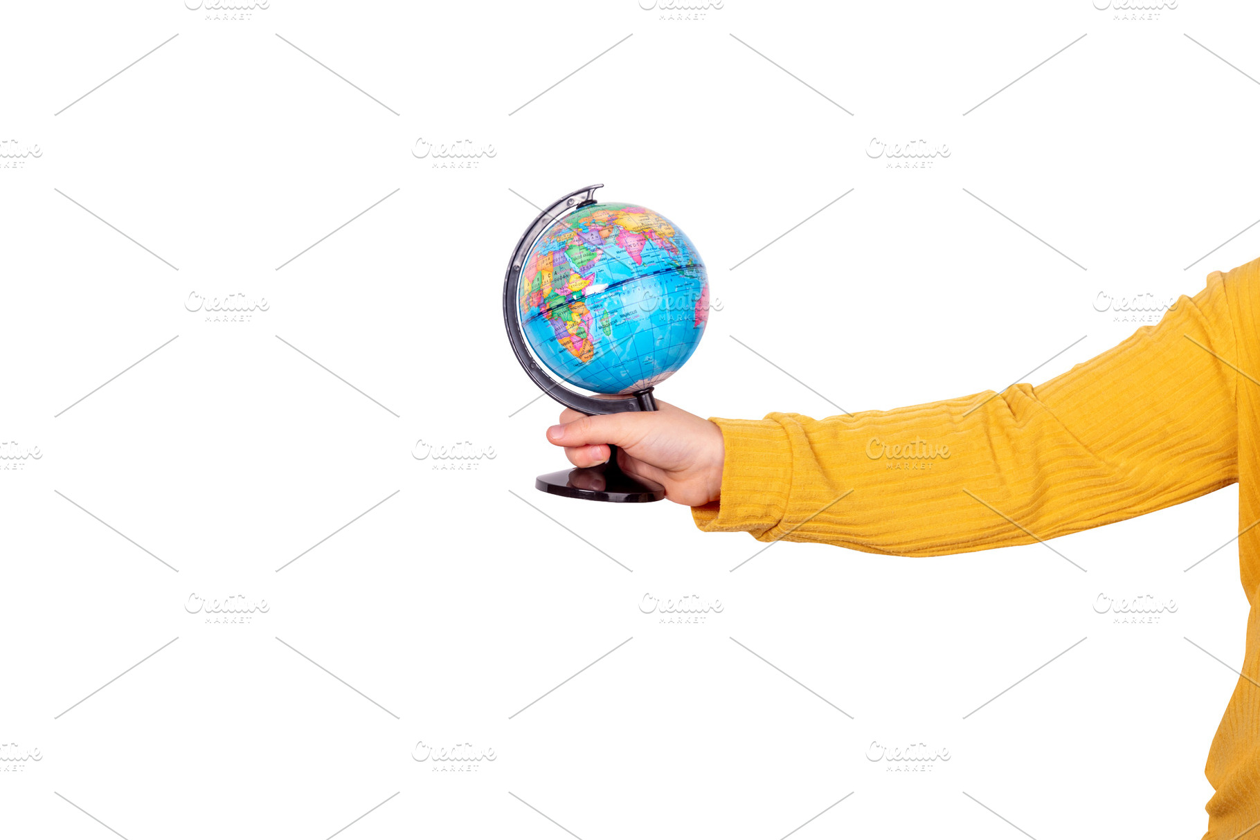 Close-up of a hand in a yellow sleeve holding a world globe isol, a School & Education Photo by Ales Munt