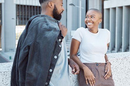 Talking, black people and couple of friends in a city with happiness and conversation outdoor. Urban lifestyle, happy woman and communication by a building with partner and smile from discussion, a Photo by Peopleimages.com