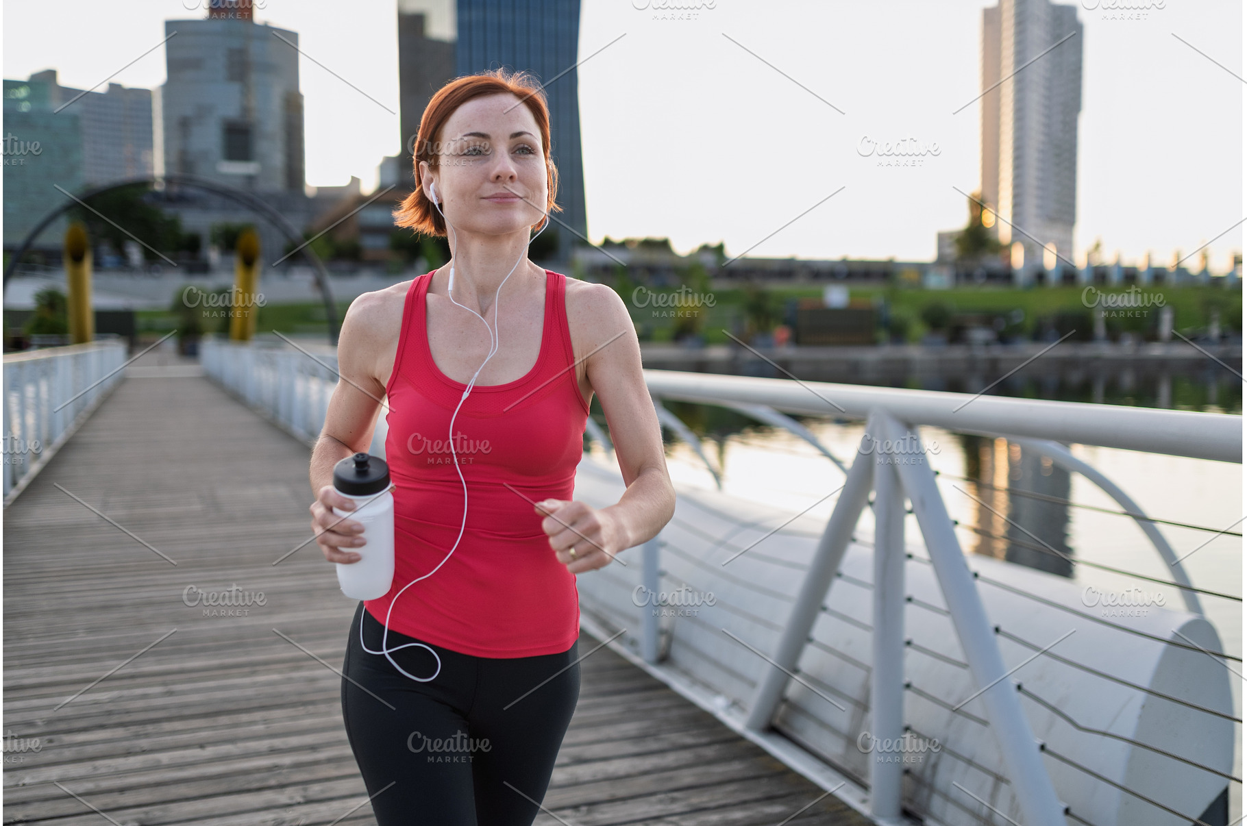 sporty woman running across a city, a Person Photo by HalfPoint
