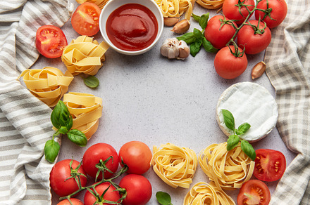 Frame of pasta ingredients forming a border on a gray background, a Food & Drink Photo by Olena Rudo
