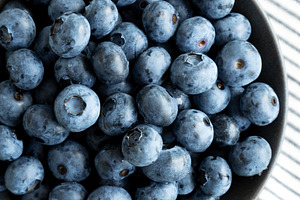 Raw Organic Blueberries in a Bowl, top view. Overhead, from abov, a Food & Drink Photo by LiudmylaChuhunova
