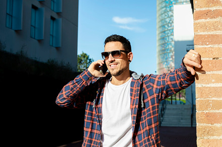 Young man smiling and talking on mobile phone outside, a Person Photo by RF Images